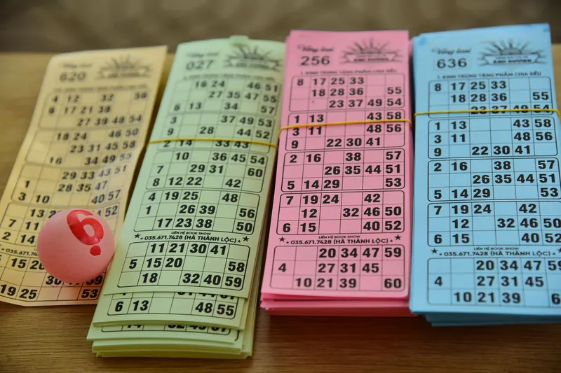 Colorful bingo cards and a numbered ball on a table