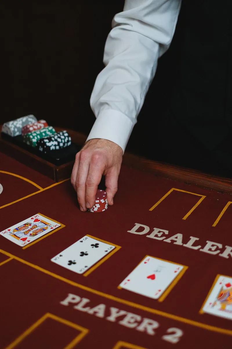 A blackjack table setup with a dealer's hands over the layout