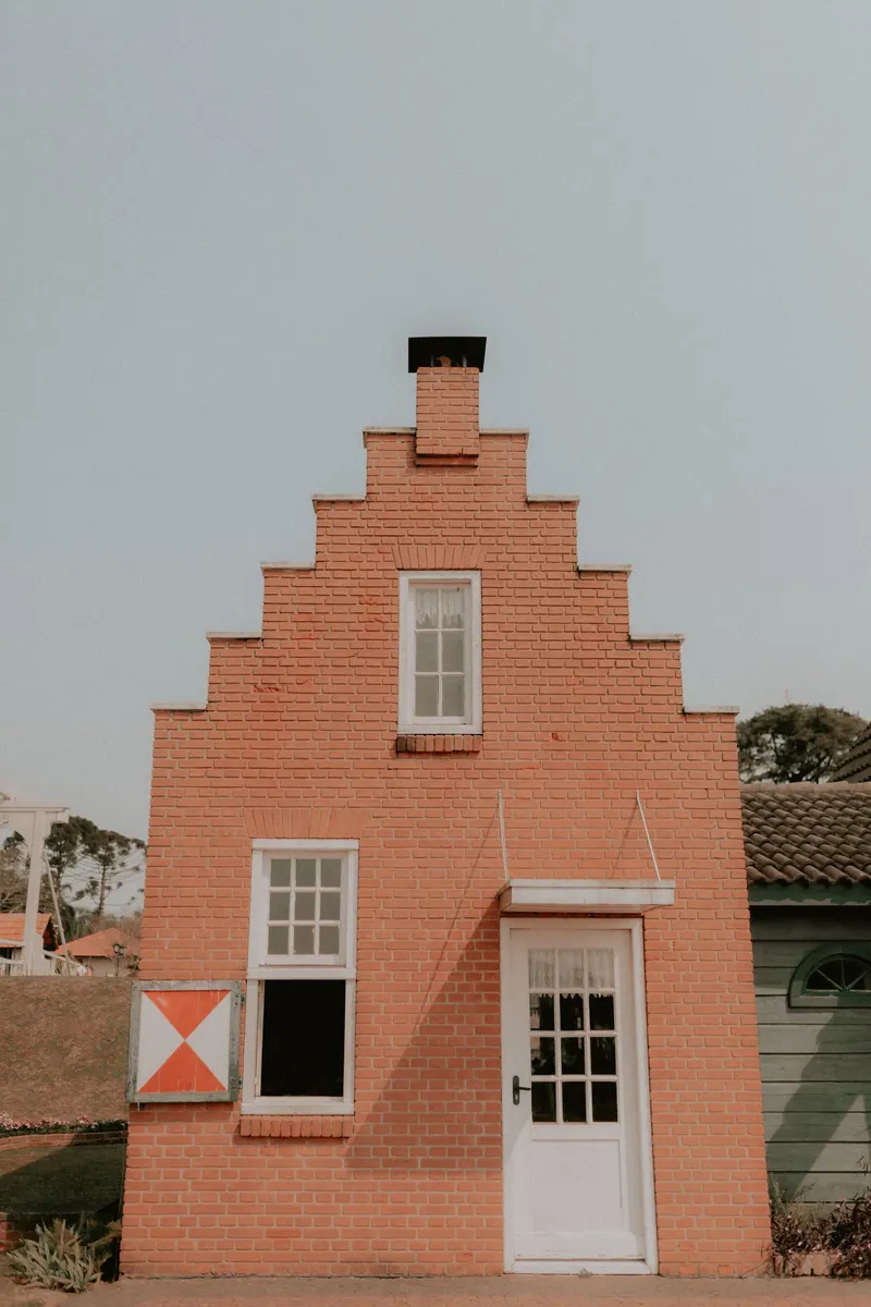 A traditional brick house with a stepped gable facade under a clear sky, ideal for home and architecture themes