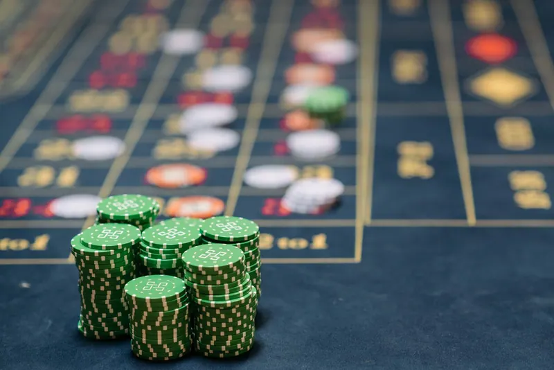 Stack of green poker chips on a casino table, highlighting the gambling theme