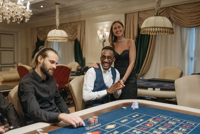 Three people enjoying a night at an elegant casino gambling table