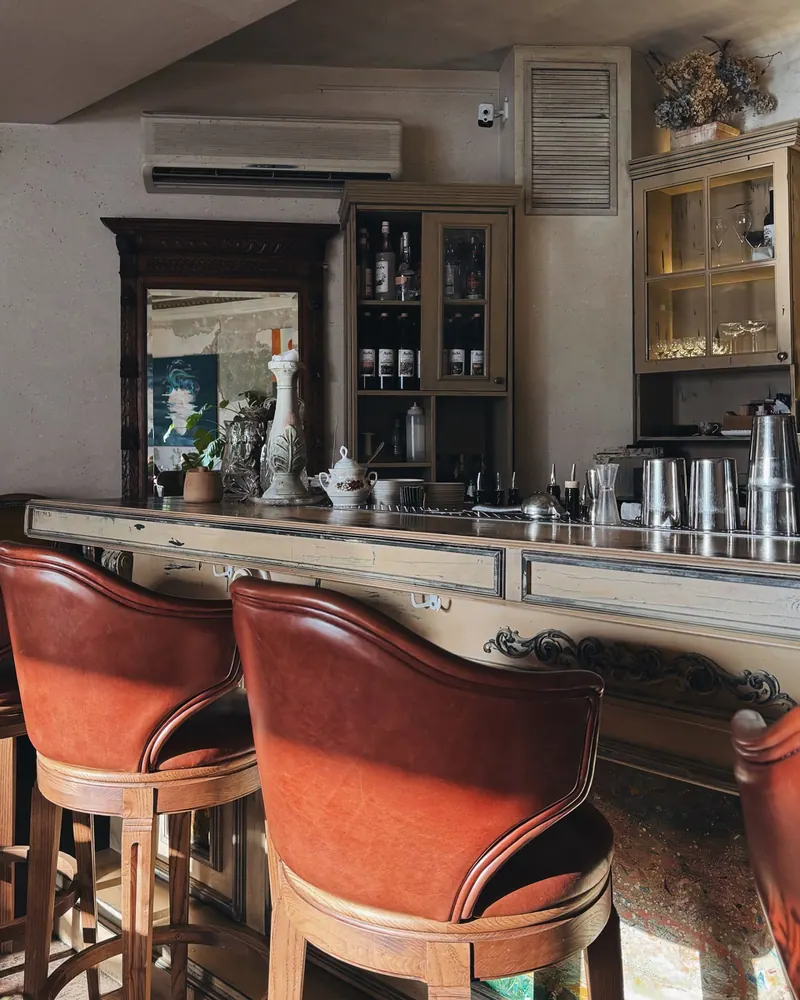 Stylish bar interior featuring vintage decor, leather chairs, and warm lighting for a cozy ambiance