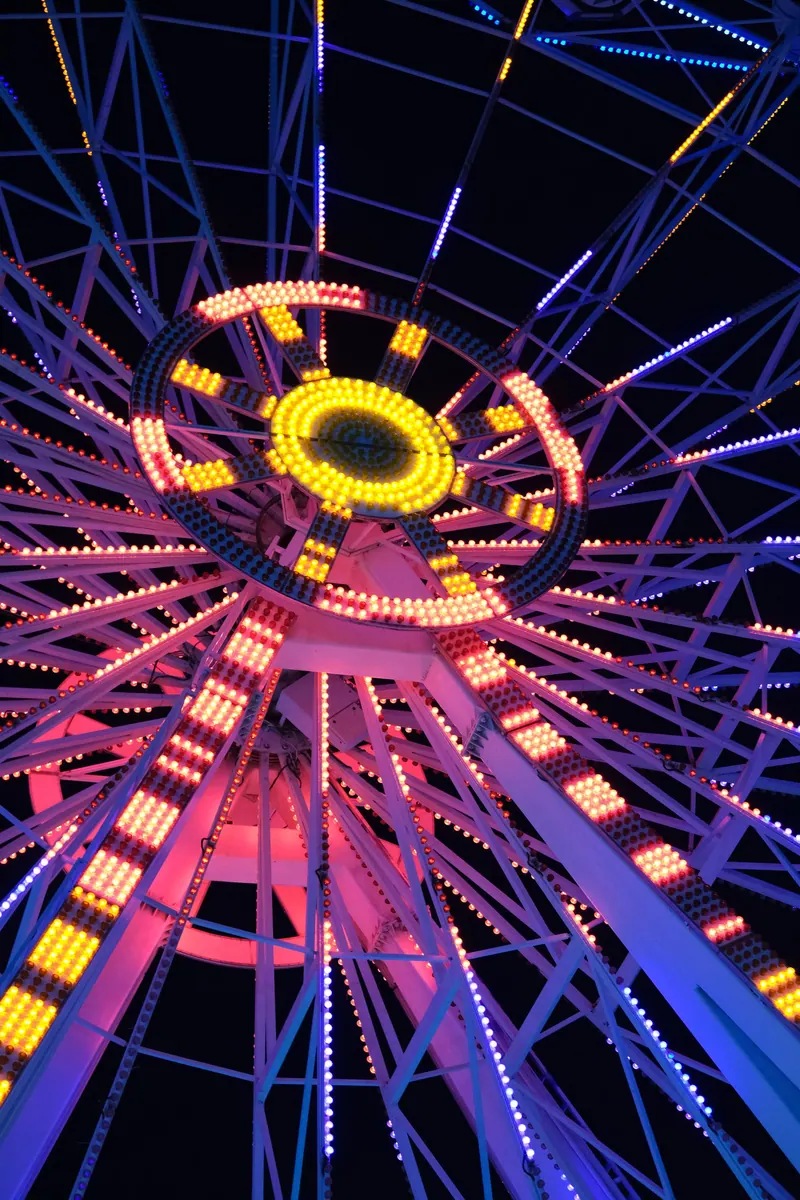A colorful neon-lit spinning wheel at night