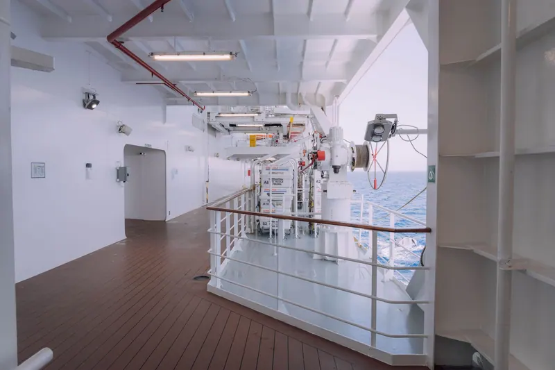 Spacious cruise ship deck featuring safety equipment and ocean view, ideal for travel themes