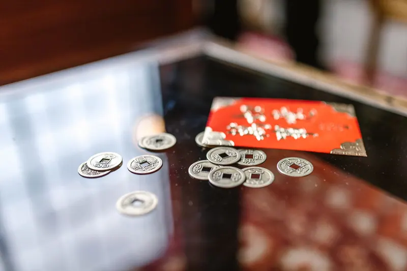A table with traditional Chinese coins and a red envelope, symbolizing prosperity and luck