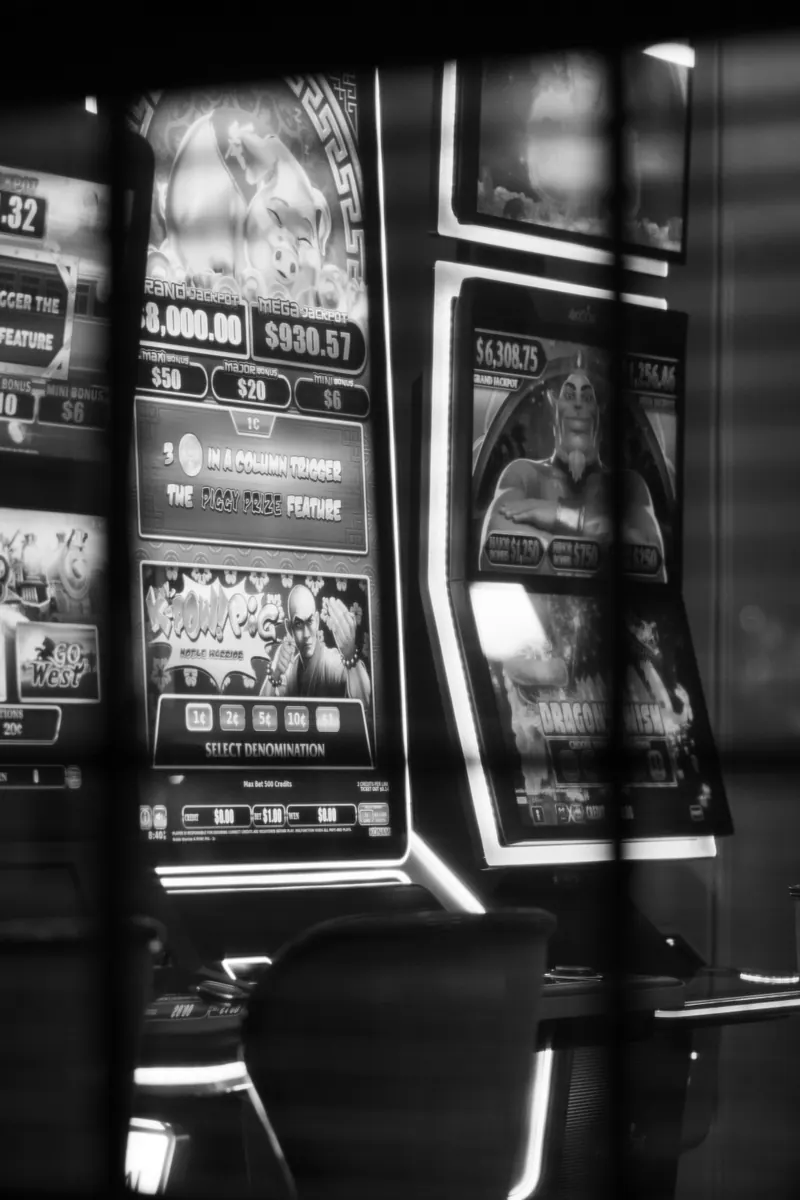 Black and white photograph of illuminated slot machine cabinets