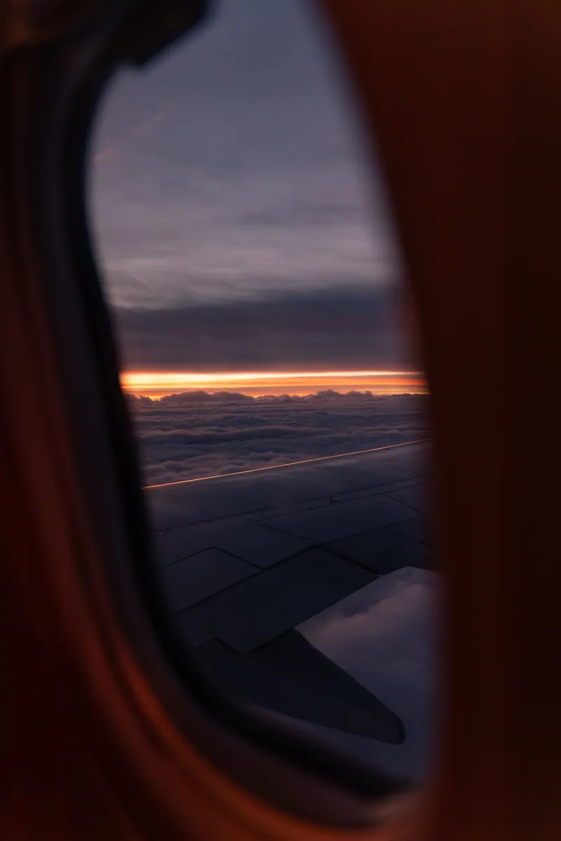 Airplane wing over a sunset sky seen from the window