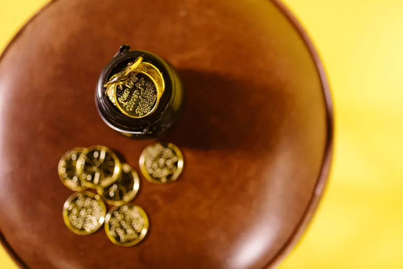 Overhead shot of gold coins on a brown surface against a yellow background