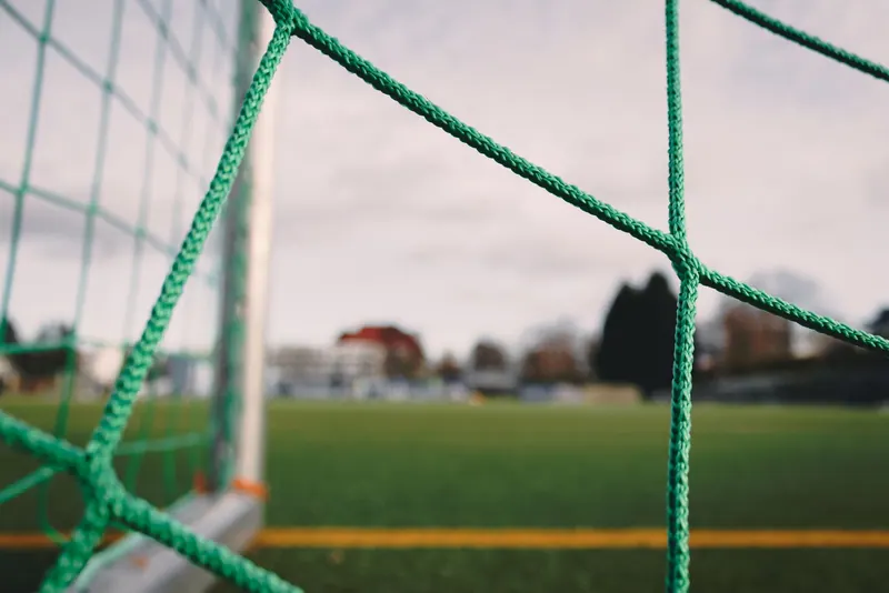 A close-up of a soccer goal net facing the field