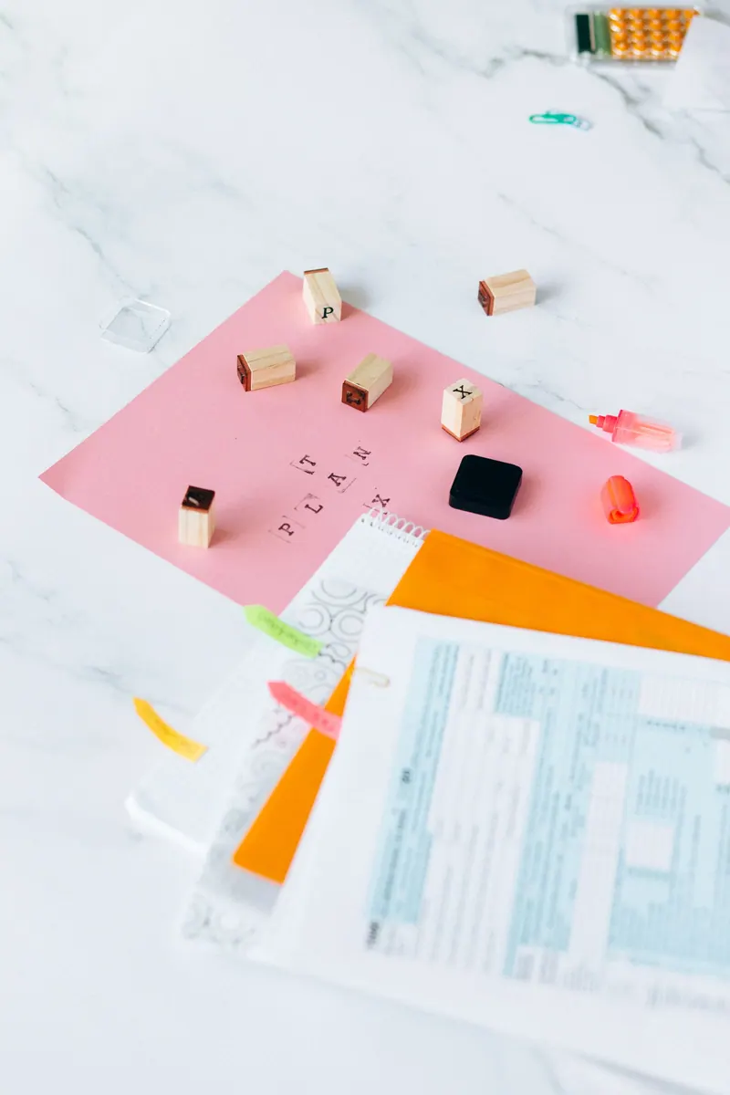 US tax forms and rubber letter stamps arranged on a marble desk