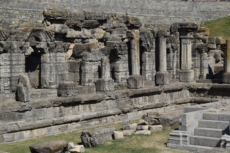 Explore the ancient stone ruins and columns of a historic temple under daylight.