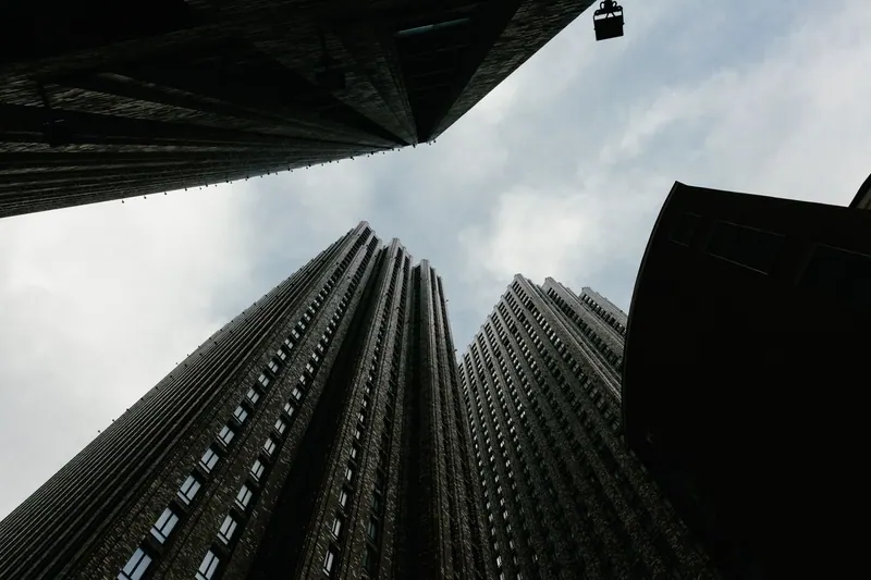 Looking up at modern skyscrapers with a dramatic sky backdrop, captured in a cityscape setting