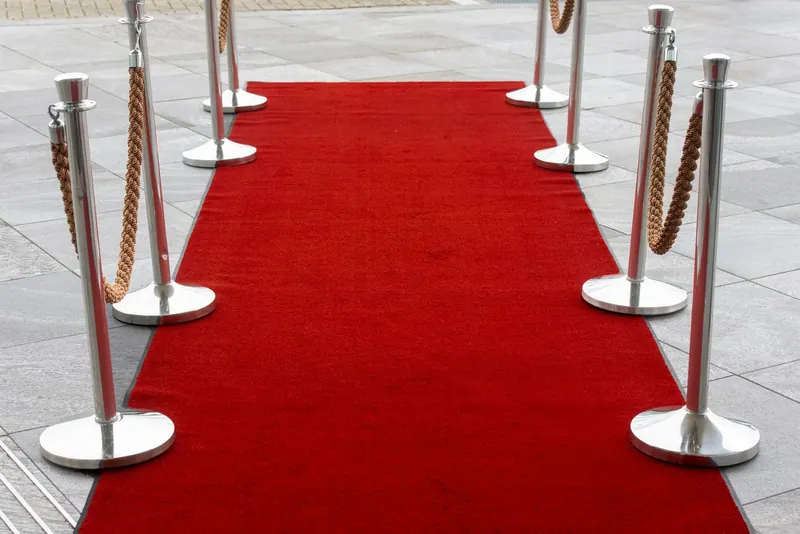 Red carpet entrance with stanchions on a tiled outdoor surface