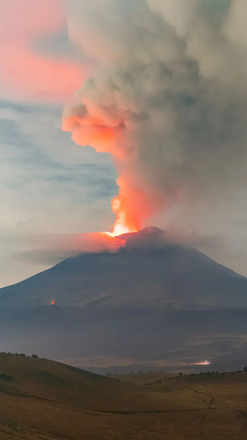A dramatic eruption of Popocatépetl volcano in Mexico, showcasing fiery lava and smoke billowing into the sky