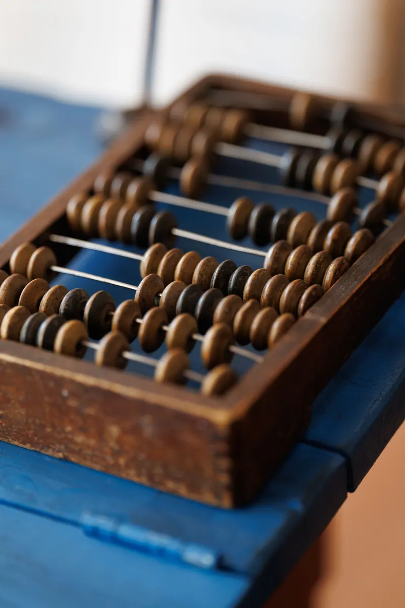 Rows of dark wooden beads on an abacus
